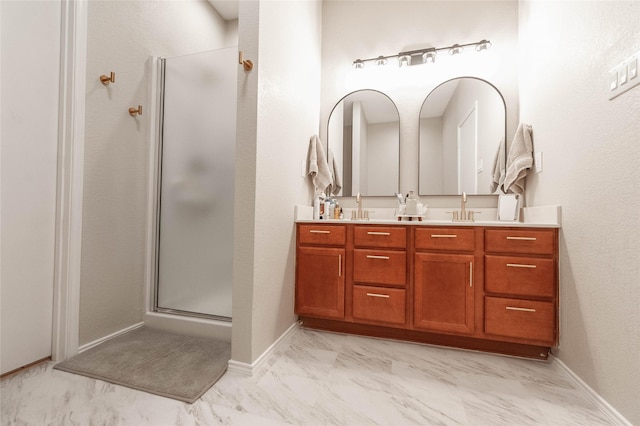 full bathroom featuring a sink, baseboards, marble finish floor, a shower stall, and double vanity