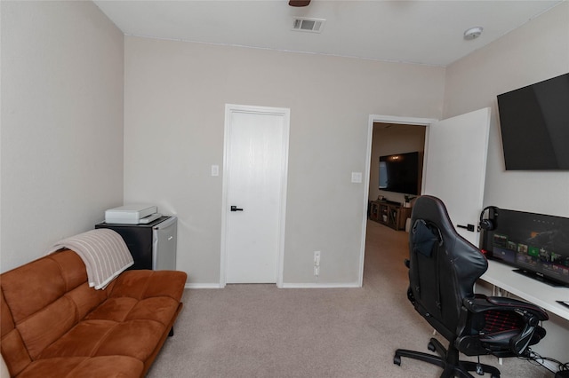 office area with baseboards, visible vents, and light colored carpet