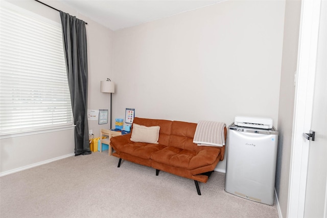 sitting room featuring light carpet and baseboards