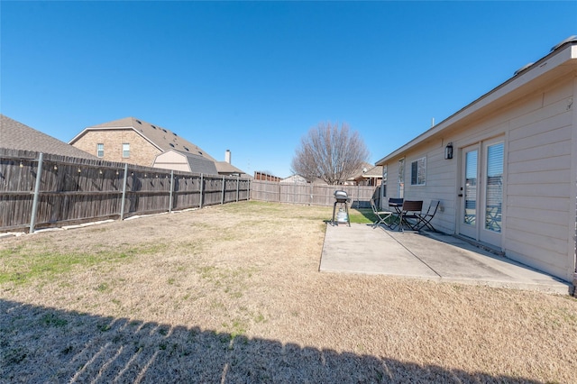 view of yard featuring a patio area, a fenced backyard, and french doors