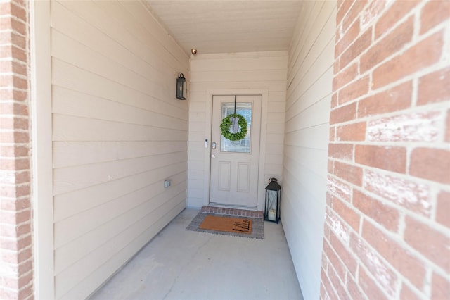 doorway to property featuring brick siding