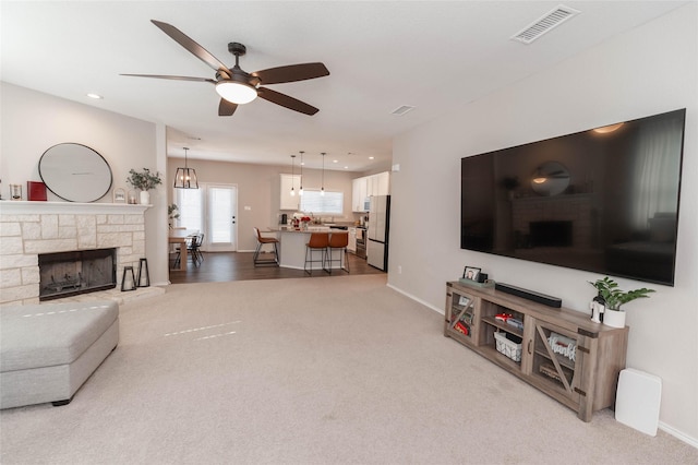 living area with light carpet, visible vents, and baseboards