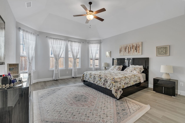 bedroom with light wood-style flooring, multiple windows, visible vents, and baseboards