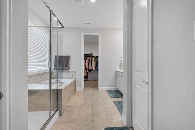 bathroom featuring a garden tub, visible vents, a spacious closet, a stall shower, and tile patterned floors