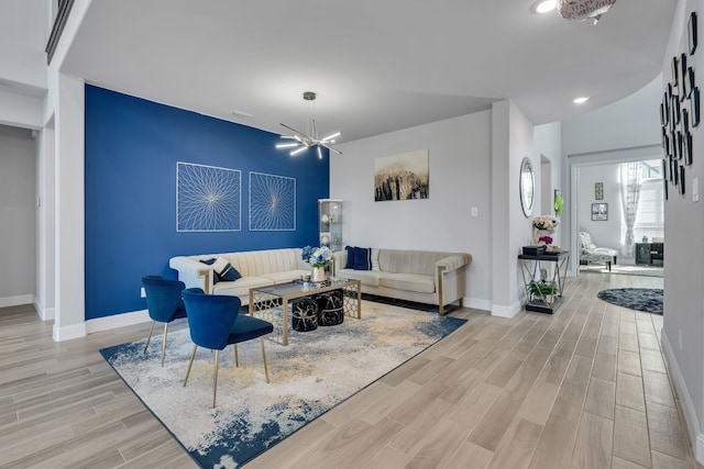 living room with baseboards, recessed lighting, light wood-type flooring, and a notable chandelier