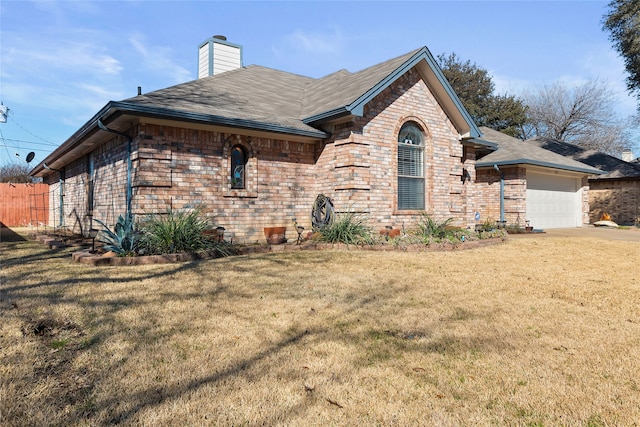 view of front of house featuring brick siding, a chimney, an attached garage, and a front yard