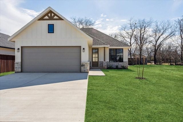 modern farmhouse style home featuring board and batten siding, a front yard, stone siding, and roof with shingles