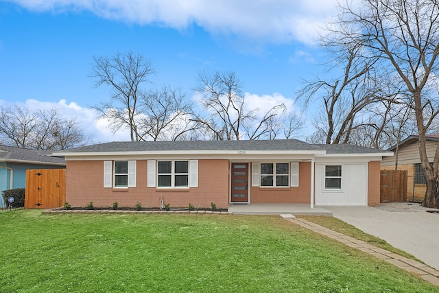 ranch-style home featuring a front yard, brick siding, and fence