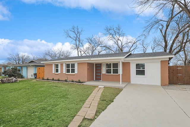 single story home featuring a front yard, fence, and brick siding