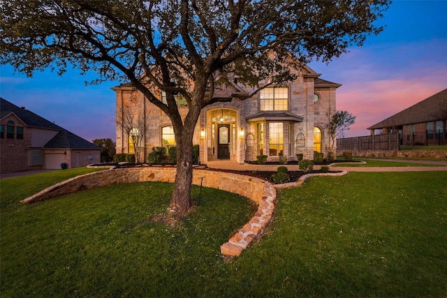 french country inspired facade with stone siding and a front lawn