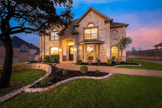 french country home with a front yard and fence