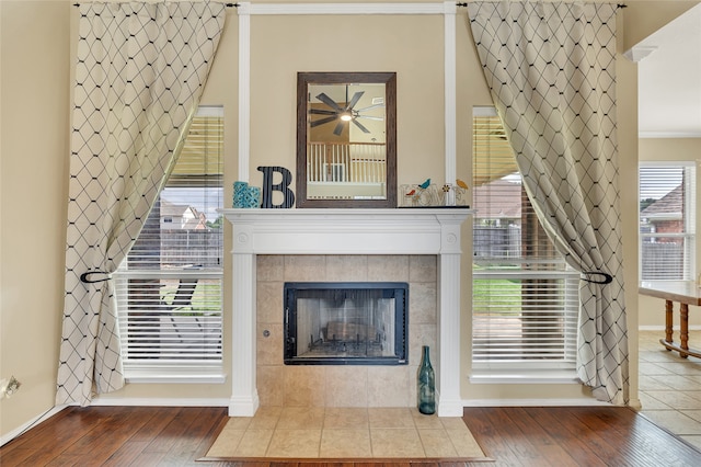 unfurnished living room featuring wood-type flooring, crown molding, and a tiled fireplace