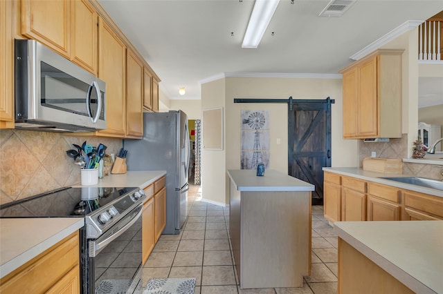 kitchen with stainless steel appliances, a barn door, light countertops, and light brown cabinetry