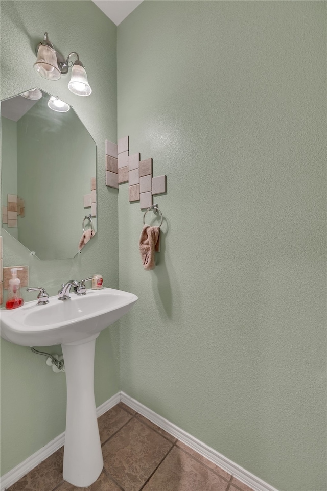 bathroom featuring tile patterned flooring, baseboards, and a sink