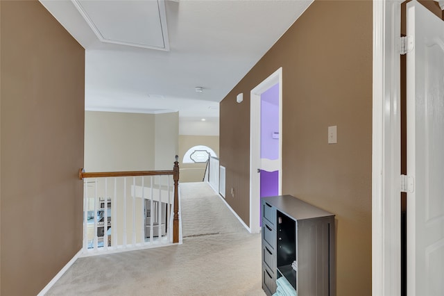 hall featuring baseboards, an upstairs landing, and light colored carpet