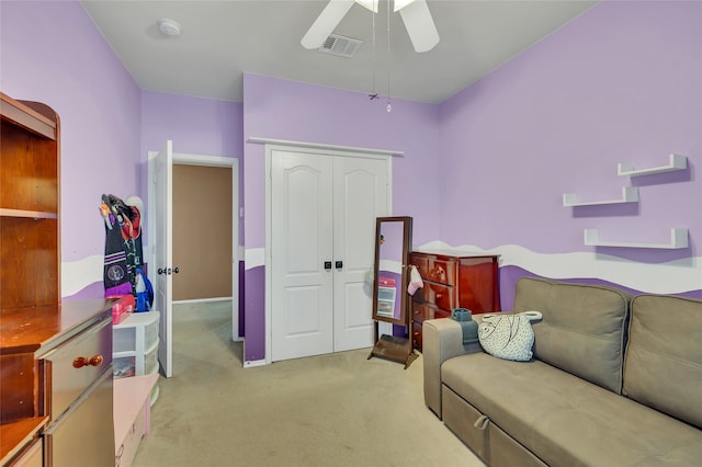 interior space with light carpet, a closet, visible vents, and a ceiling fan