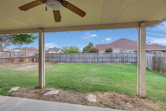 view of yard with a fenced backyard and a ceiling fan