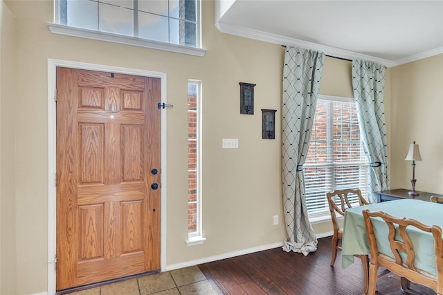 foyer with crown molding, baseboards, and wood finished floors