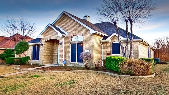 view of front of home with a chimney and a front yard