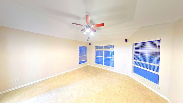 empty room with a ceiling fan and baseboards