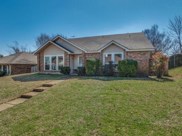 single story home with roof with shingles, fence, a front lawn, and brick siding