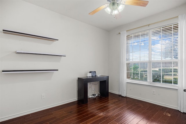 empty room with dark wood-style floors, ceiling fan, and baseboards