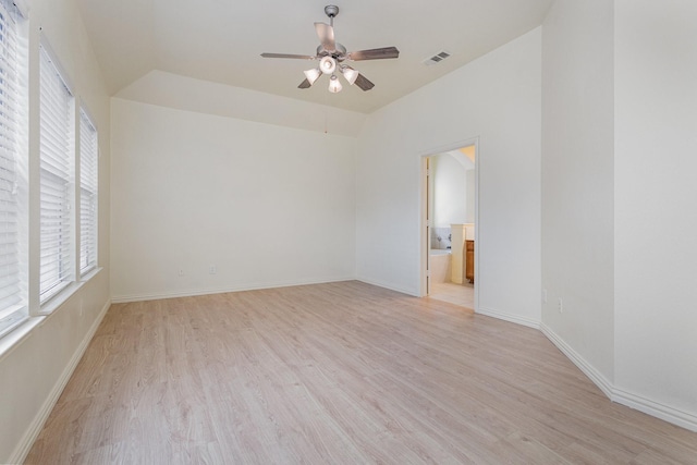 spare room with visible vents, light wood-style floors, vaulted ceiling, ceiling fan, and baseboards