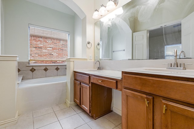 bathroom with a garden tub, a sink, and tile patterned floors