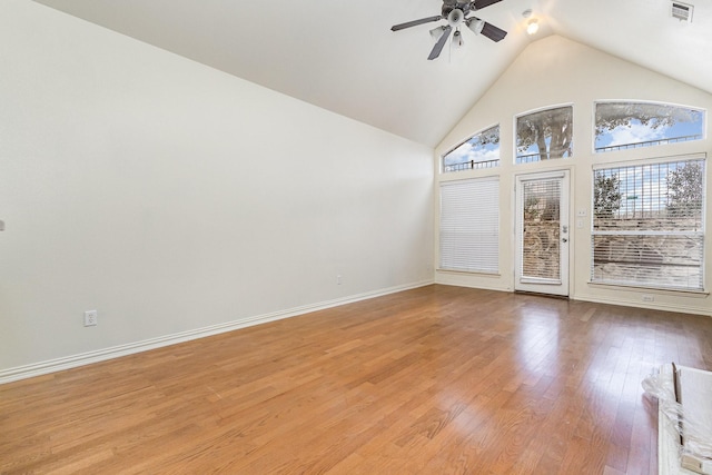 empty room with ceiling fan, high vaulted ceiling, light wood-style flooring, visible vents, and baseboards