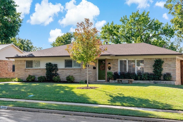 ranch-style house with brick siding, roof with shingles, and a front yard