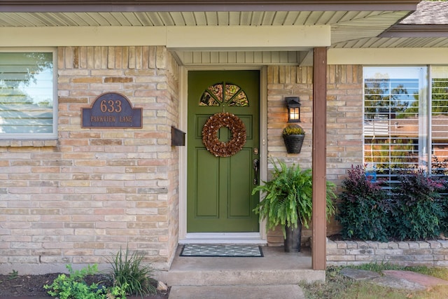 doorway to property featuring brick siding