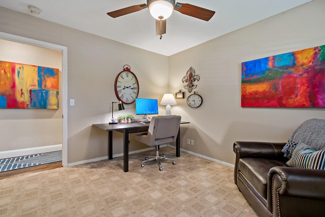 home office featuring light carpet, baseboards, and a ceiling fan