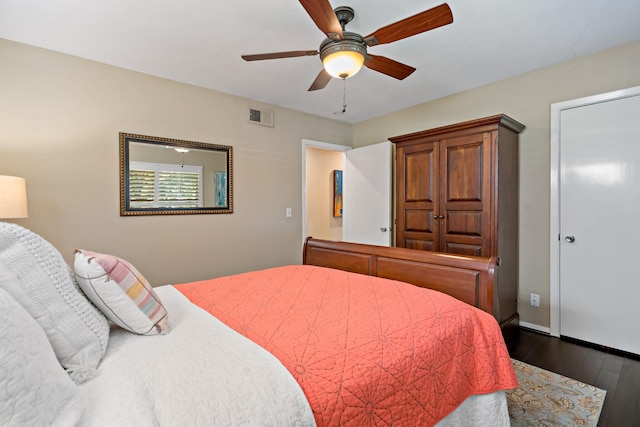 bedroom with ceiling fan, dark wood finished floors, visible vents, and baseboards