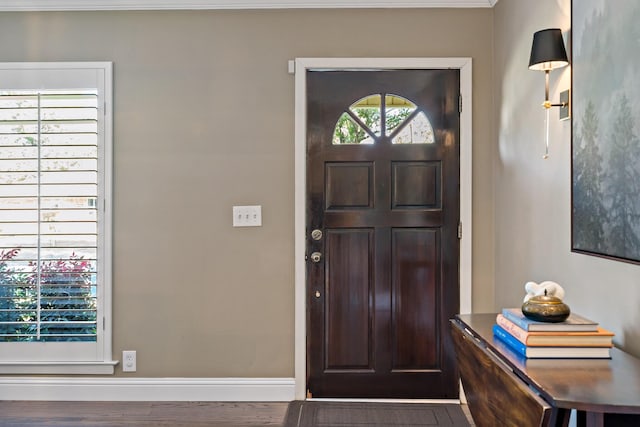 foyer with baseboards and wood finished floors