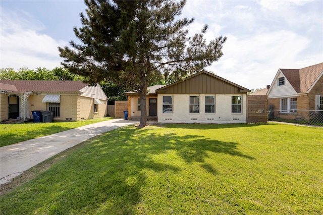 view of front facade featuring board and batten siding, brick siding, and a front lawn