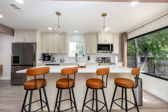 kitchen featuring stainless steel appliances, pendant lighting, light countertops, and visible vents