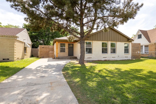 single story home with crawl space, fence, a front lawn, board and batten siding, and brick siding