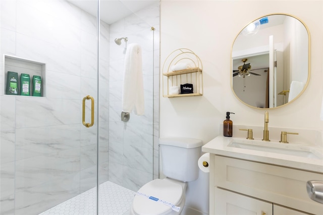 bathroom featuring toilet, a stall shower, a ceiling fan, and vanity