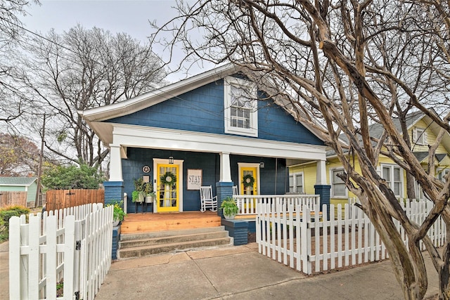 view of front of house with covered porch and a fenced front yard