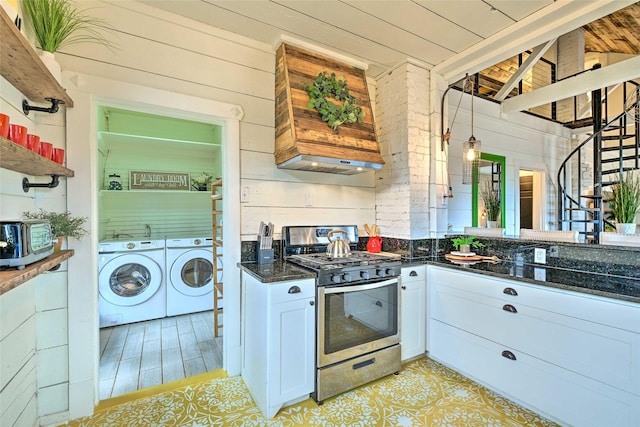 kitchen with white cabinets, stainless steel gas range, independent washer and dryer, dark stone counters, and open shelves