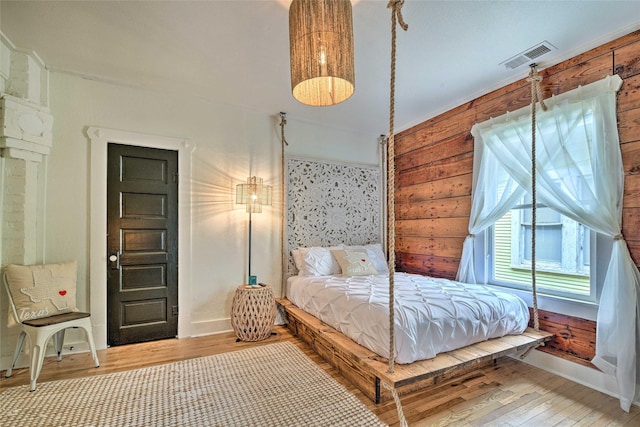 bedroom featuring visible vents, baseboards, and wood finished floors