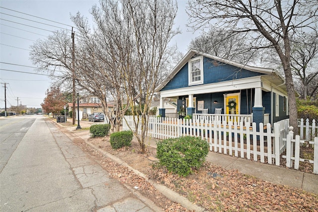 bungalow featuring a porch and a fenced front yard