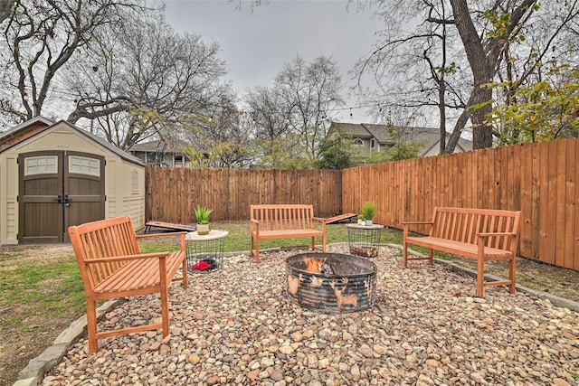 view of patio / terrace with an outdoor fire pit, a storage unit, a fenced backyard, and an outdoor structure