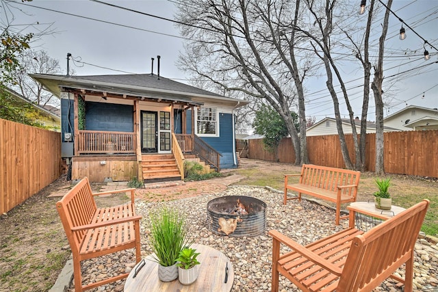 back of house featuring an outdoor fire pit, a fenced backyard, and roof with shingles