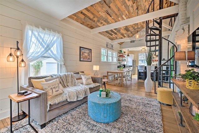 living area with wood walls, wood finished floors, and beam ceiling