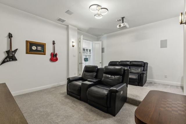 home theater featuring light carpet, visible vents, and baseboards