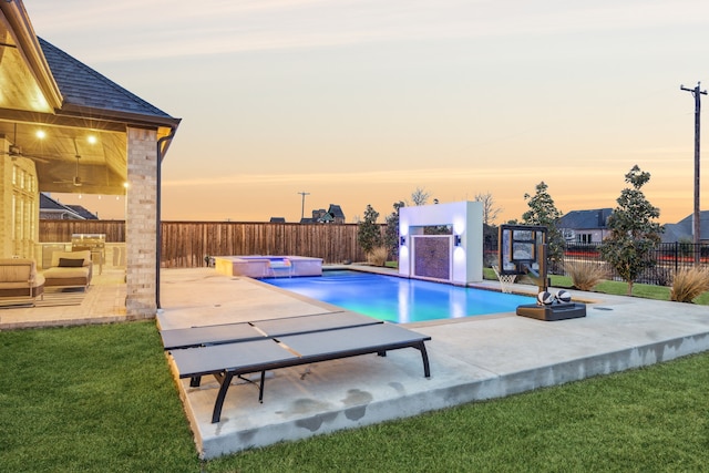 view of pool featuring a yard, a fenced backyard, a pool with connected hot tub, and a patio