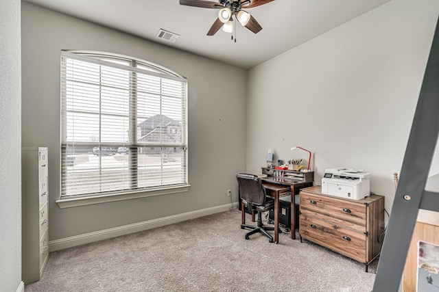 office featuring light colored carpet, visible vents, ceiling fan, and baseboards