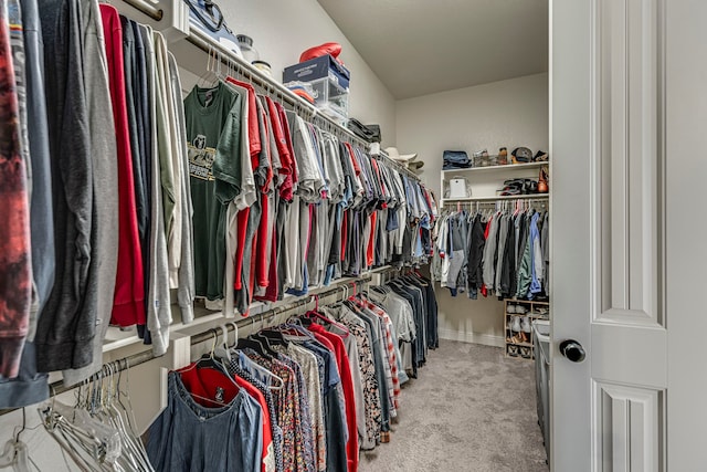 walk in closet featuring light colored carpet