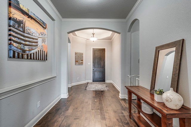 entrance foyer featuring baseboards, arched walkways, dark wood-style flooring, and crown molding